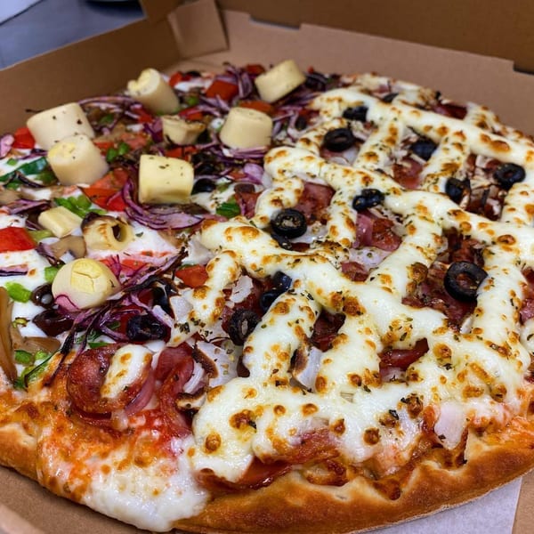 A Via Capri Pizzeria pizza with two distinct halves, one with artichoke hearts, the other with black olives.