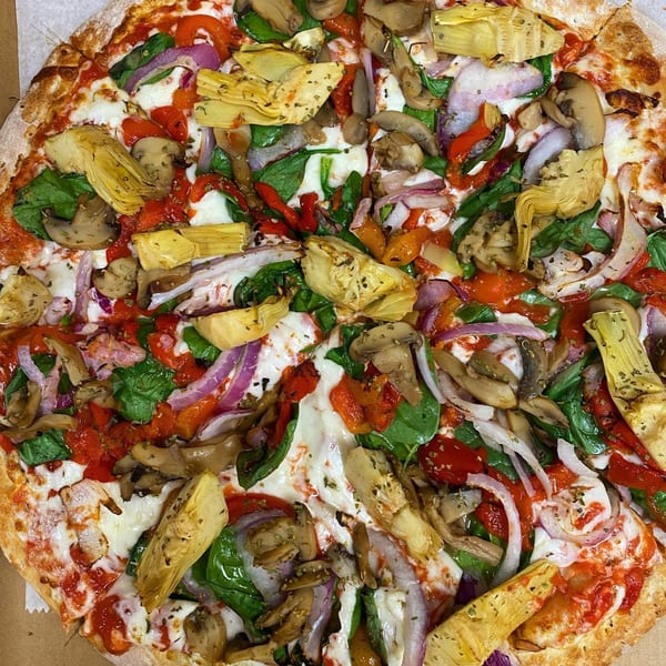 Via Capri Pizzeria's vegetarian pizza, topped with spinach, red onion, mushrooms, roasted red peppers, and artichoke hearts.