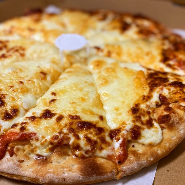 A freshly baked Via Capri Pizzeria cheese pizza with a golden crust and melted, bubbly cheese.